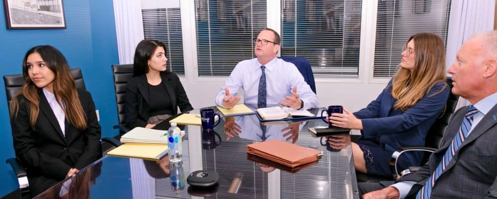 Lanzone Morgan, LLP attorneys talking in conference room at Long Beach, CA office