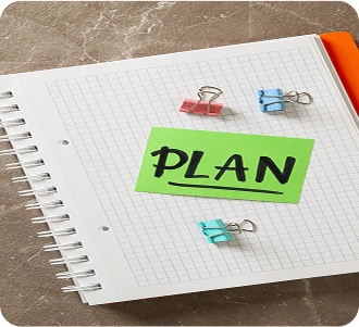 Notebook with clips and text Plan on gray background