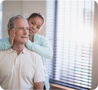 Senior male patient receiving neck massage from female therapist