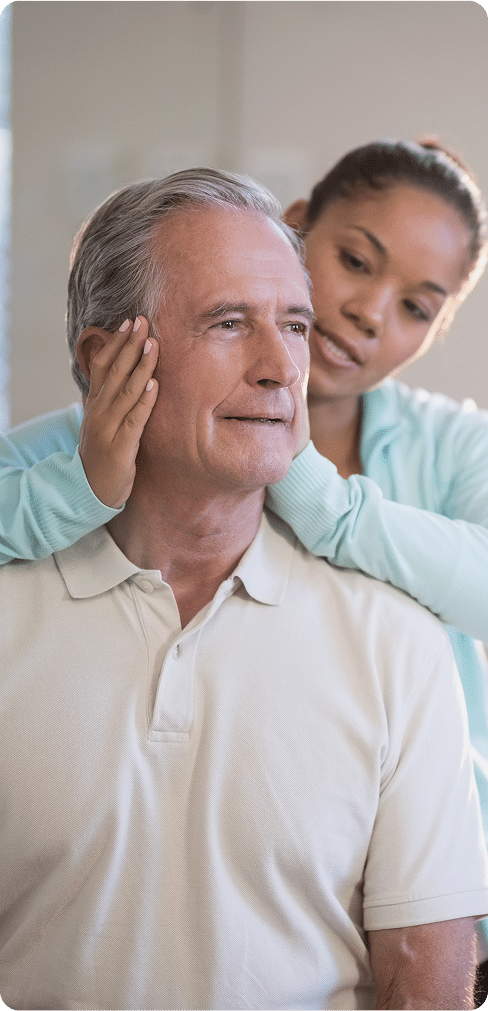 Senior male patient receiving neck massage from female therapist