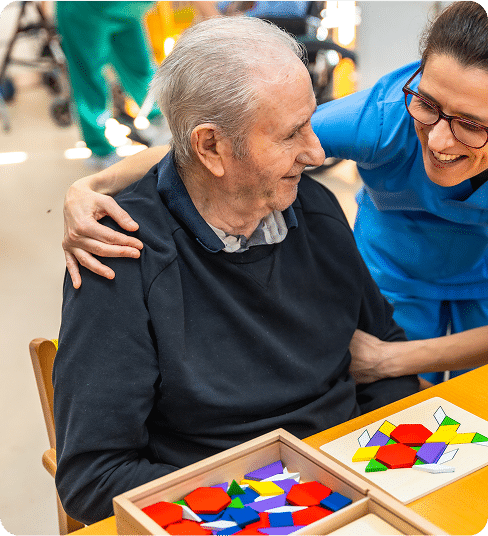 Senior man having fun with nurse playing board skill games