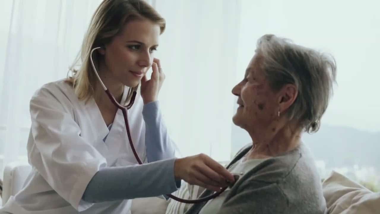 A nursing home staff testing an elderly woman with bedsore