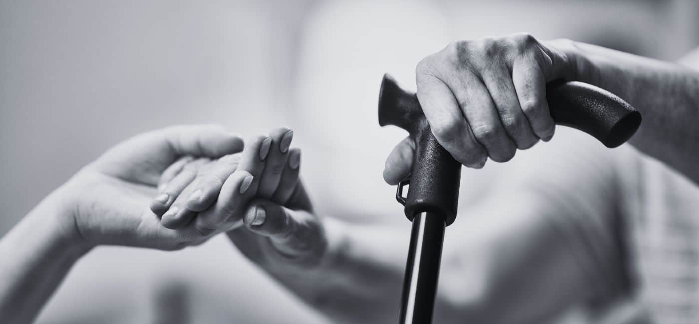 elder holding someone's hand as they stand